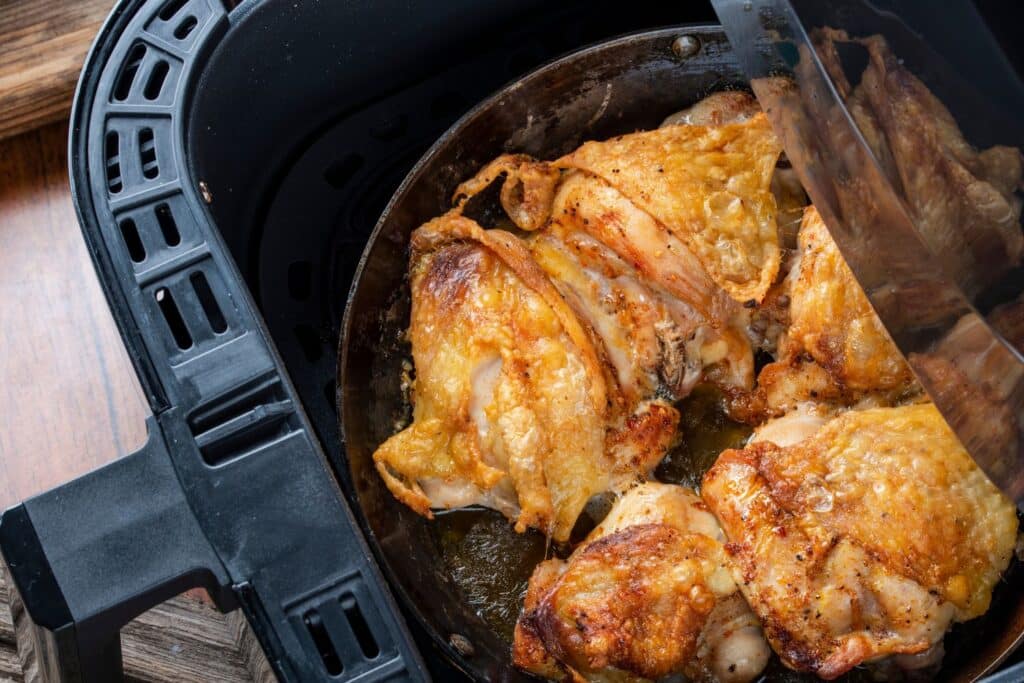 la cuve d'un air fryer avec des morceau de volaille dorés pour illustrer l'article air fryer comment ça marche
