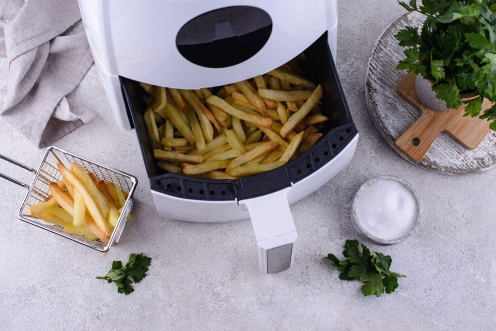 un air fryer ouvert avec des frites à l'intérieur pour illustrer l'article air fryer comment ça marche