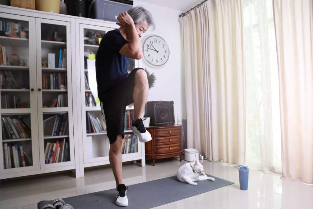un homme âgé qui fait de l'exercice dans le cadre du sport pour personne âgée à la maison